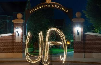 AU spelled out with sparkler in front of arch